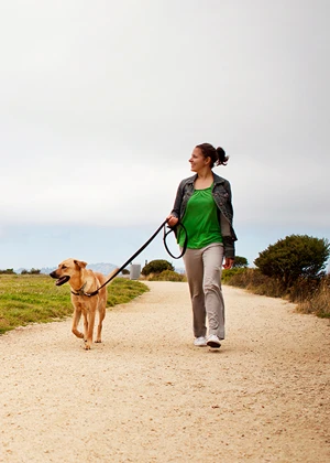 Femme promenant son chien en laisse